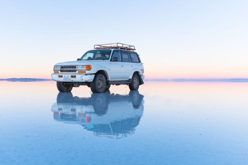 A jeep reflected on the mirror-like salt flats of Salar de Uyuni